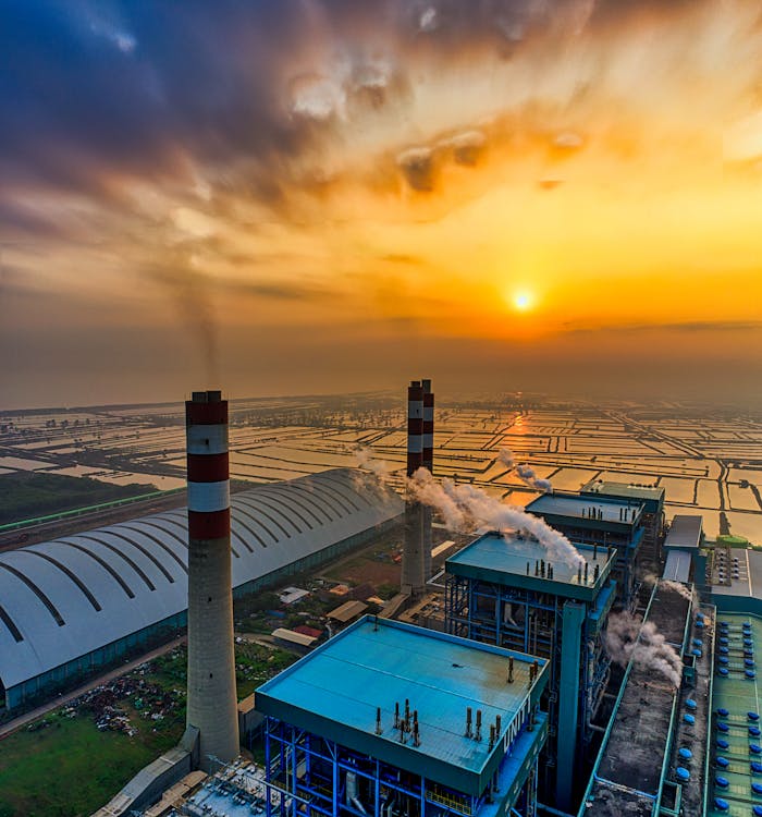 Stunning aerial shot of a refinery in Banten, Indonesia at sunset, showcasing urban industry and golden hour sky.